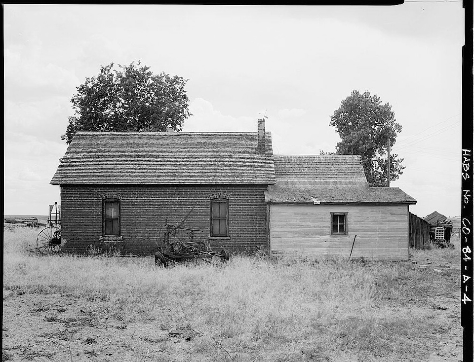 Archival photograph of the original farmhouse on open prairie