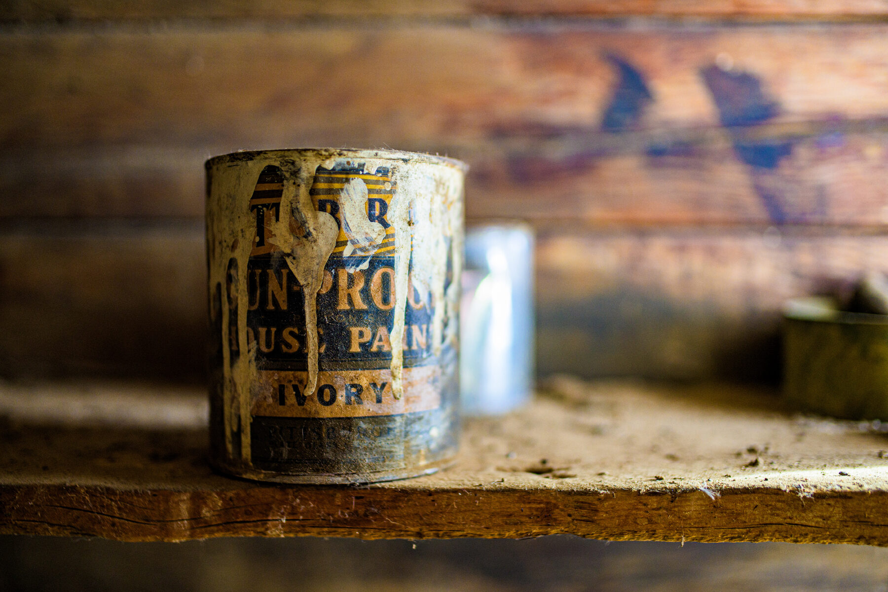 A weathered paint can from the homestead, label worn with age