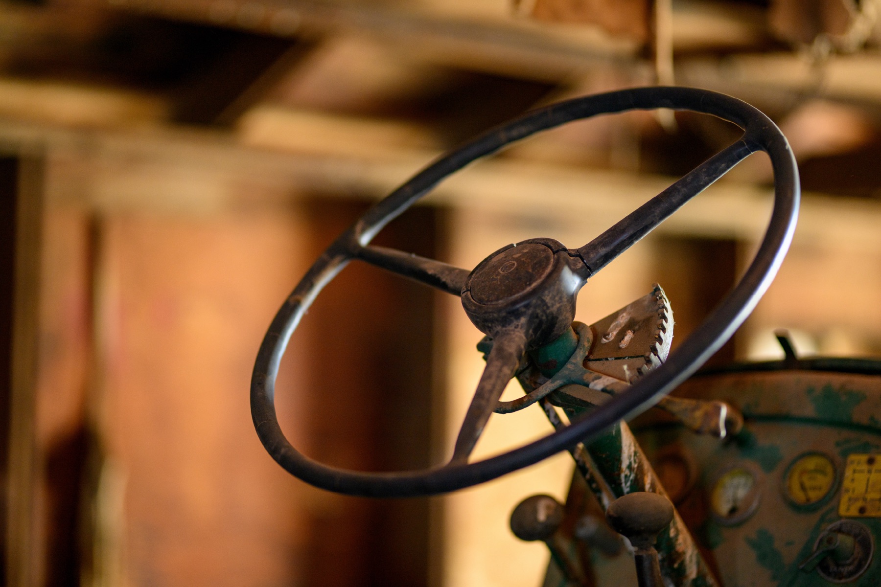 Weathered steering wheel of the homestead's original tractor, paint worn to bare steel